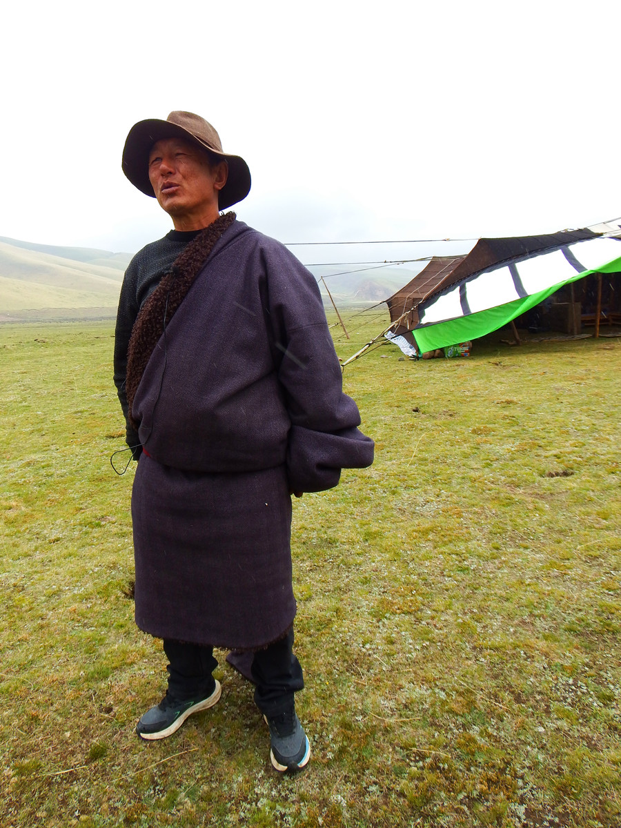 果洛藏貢麻村致富帶頭人桑杰本站在他的黑帳篷前